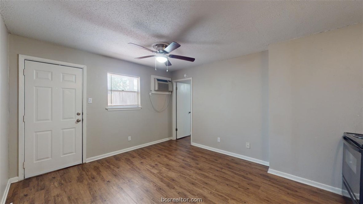 500 Foch Street, Unit 13 Bryan, TX 77801 - Photo 3 of 12 an empty room with wooden floor ceiling fan and windows