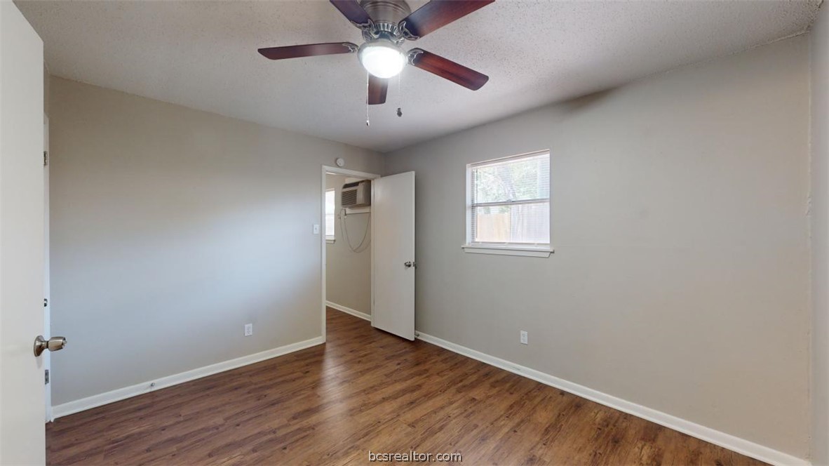 500 Foch Street, Unit 13 Bryan, TX 77801 - Photo 7 of 12 an empty room with wooden floor chandelier fan and windows