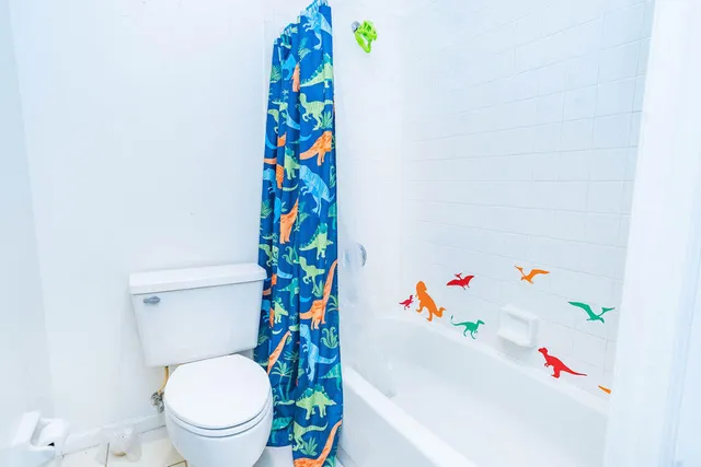 a view of a room with a chandelier fan and kitchen view