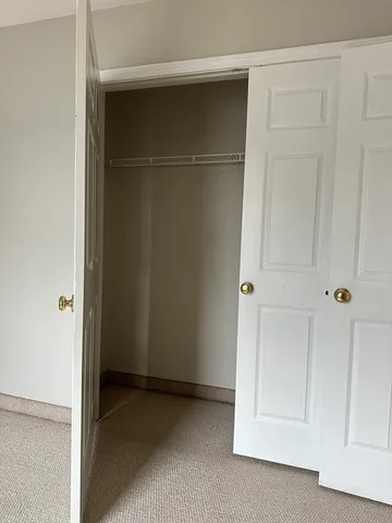 an empty room with wooden floor and mirror