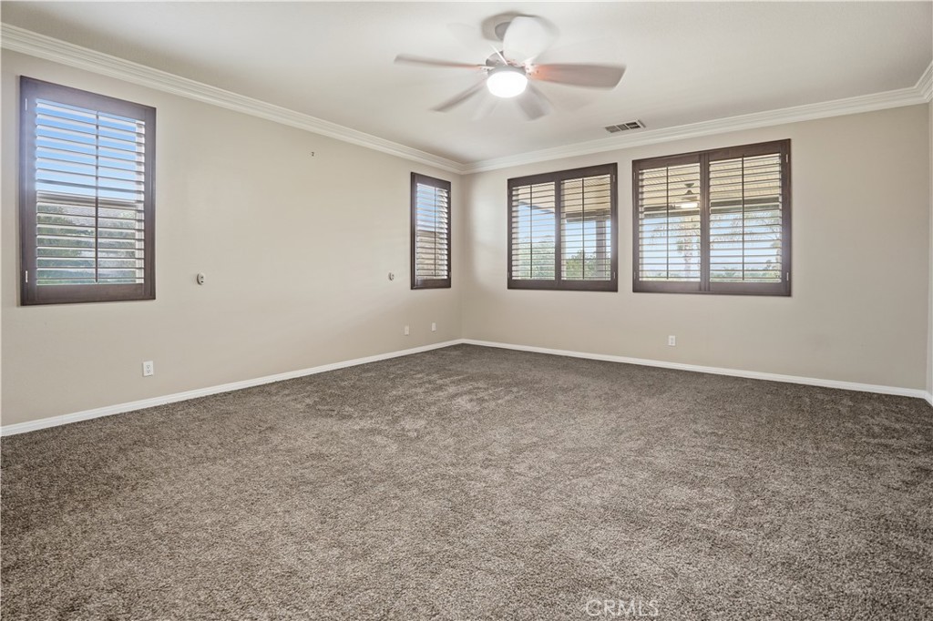 16935 Eagle Peak Road Riverside, CA 92504 - Photo 29 of 75 a big room with windows and chandelier fan