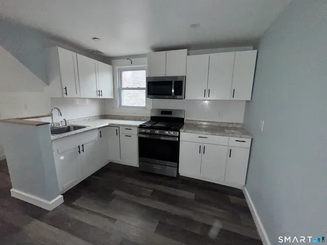 a kitchen with white cabinets and white appliances