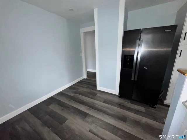 a view of kitchen with refrigerator and wooden floor