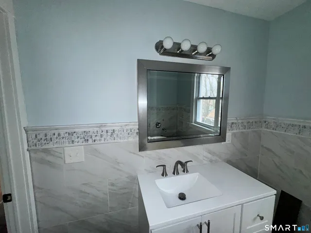 a bathroom with a sink a mirror and a bathtub
