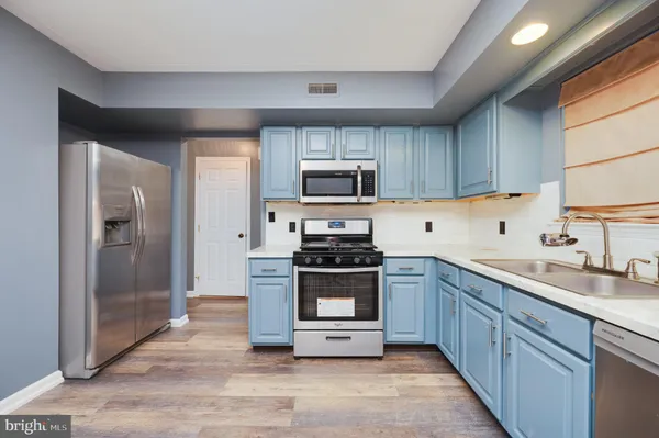 a kitchen with sink a stove and refrigerator