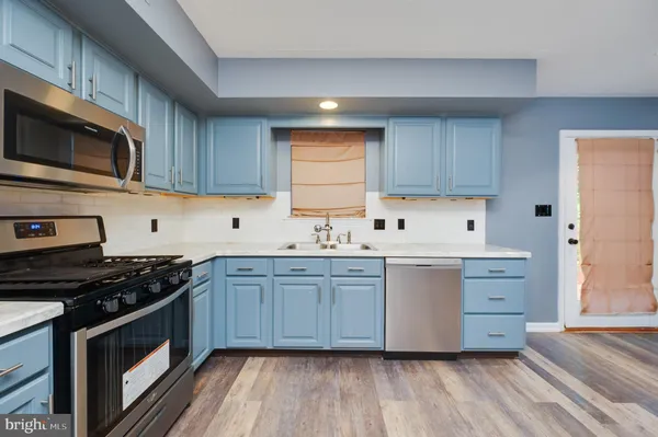 a kitchen with stainless steel appliances a stove microwave and cabinets