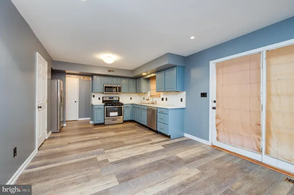 a large kitchen with stainless steel appliances granite countertop a refrigerator and a sink