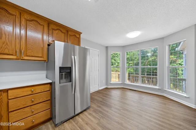 a view of a kitchen with wooden floors and stainless steel appliances