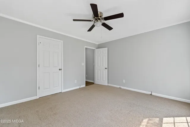 an empty room with a ceiling fan and window