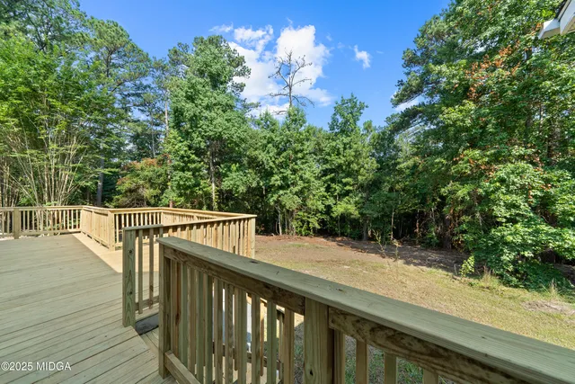 a view of a white house with wooden floor and fence