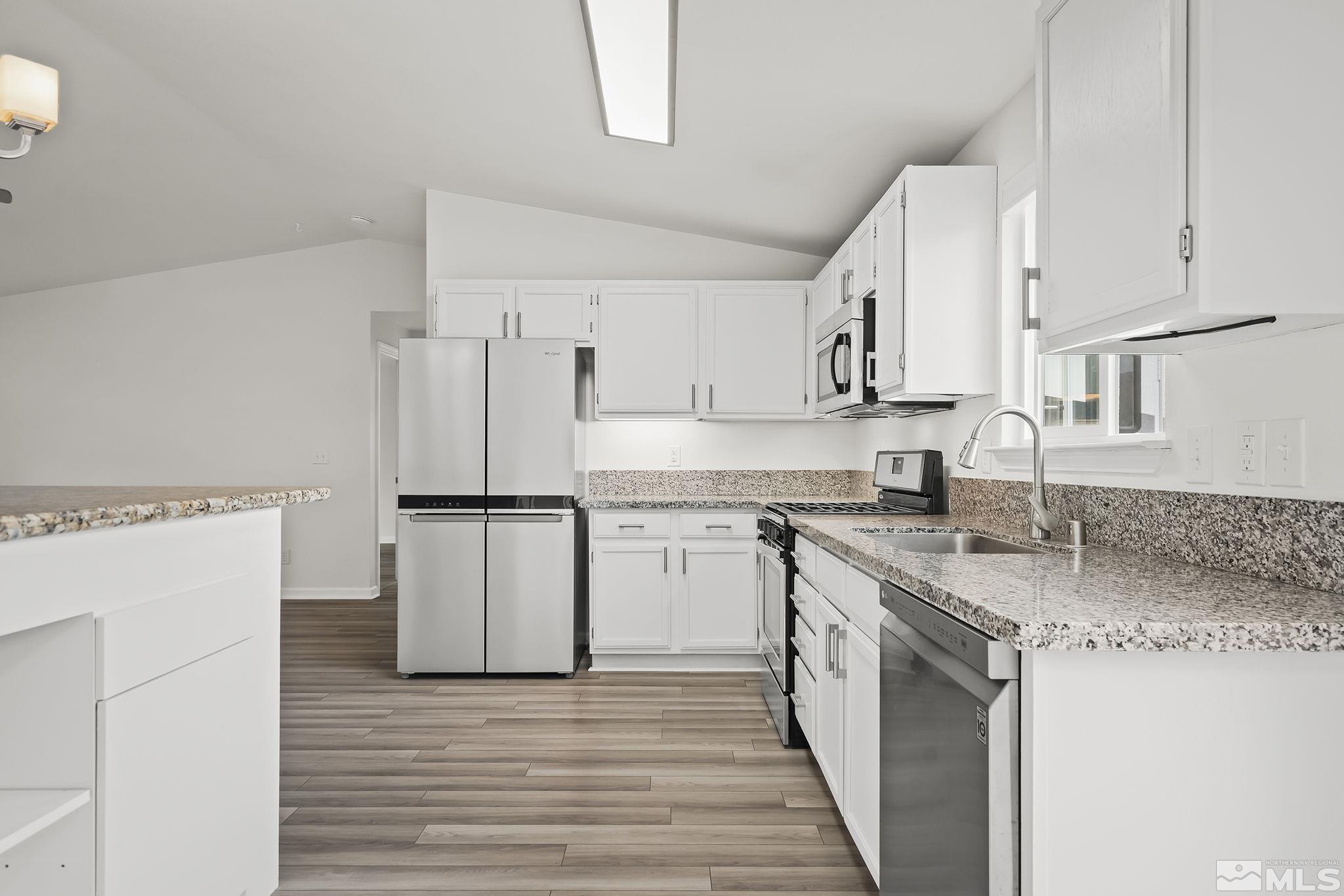 150 Rosecrest Drive Fernley, NV 89408 - Photo 12 of 28 a kitchen with stainless steel appliances granite countertop a refrigerator a stove a sink and white cabinets