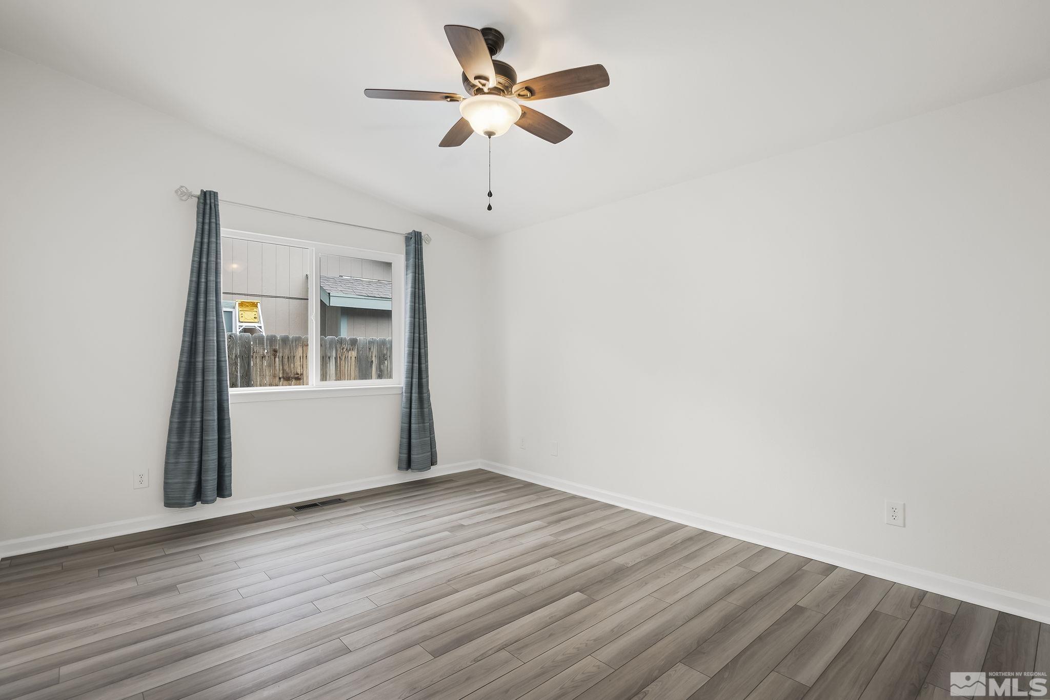 150 Rosecrest Drive Fernley, NV 89408 - Photo 14 of 28 a view of room with window ceiling fan and wooden floor