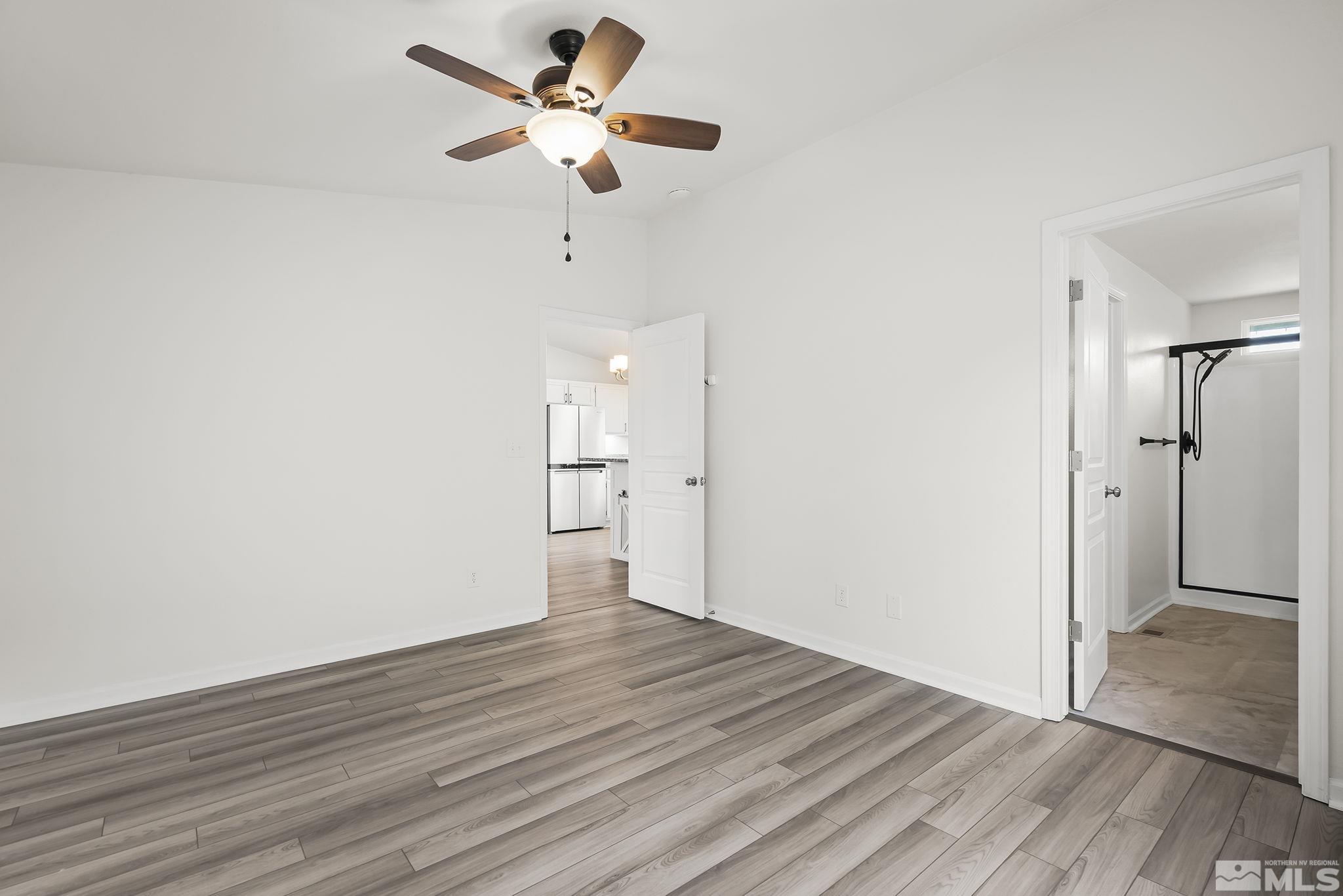 150 Rosecrest Drive Fernley, NV 89408 - Photo 15 of 28 a view of an empty room with wooden floor and a ceiling fan
