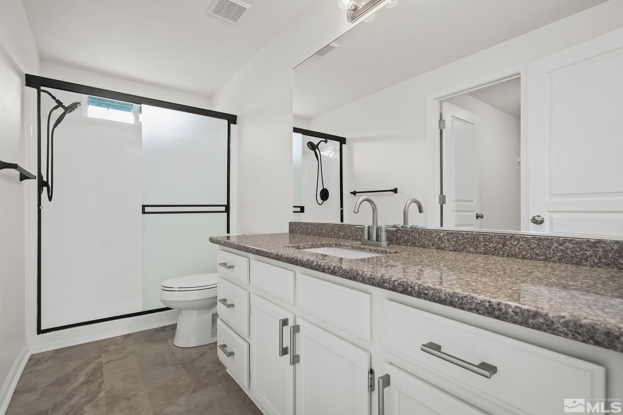 150 Rosecrest Drive Fernley, NV 89408 - Photo 16 of 28 a bathroom with a granite countertop sink mirror vanity and toilet