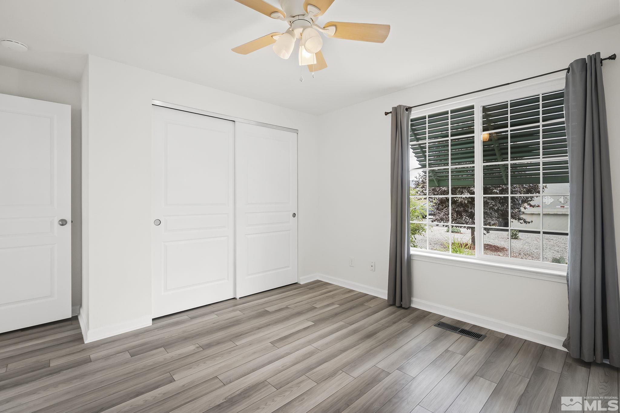 150 Rosecrest Drive Fernley, NV 89408 - Photo 19 of 28 a view of an empty room with wooden floor and a window
