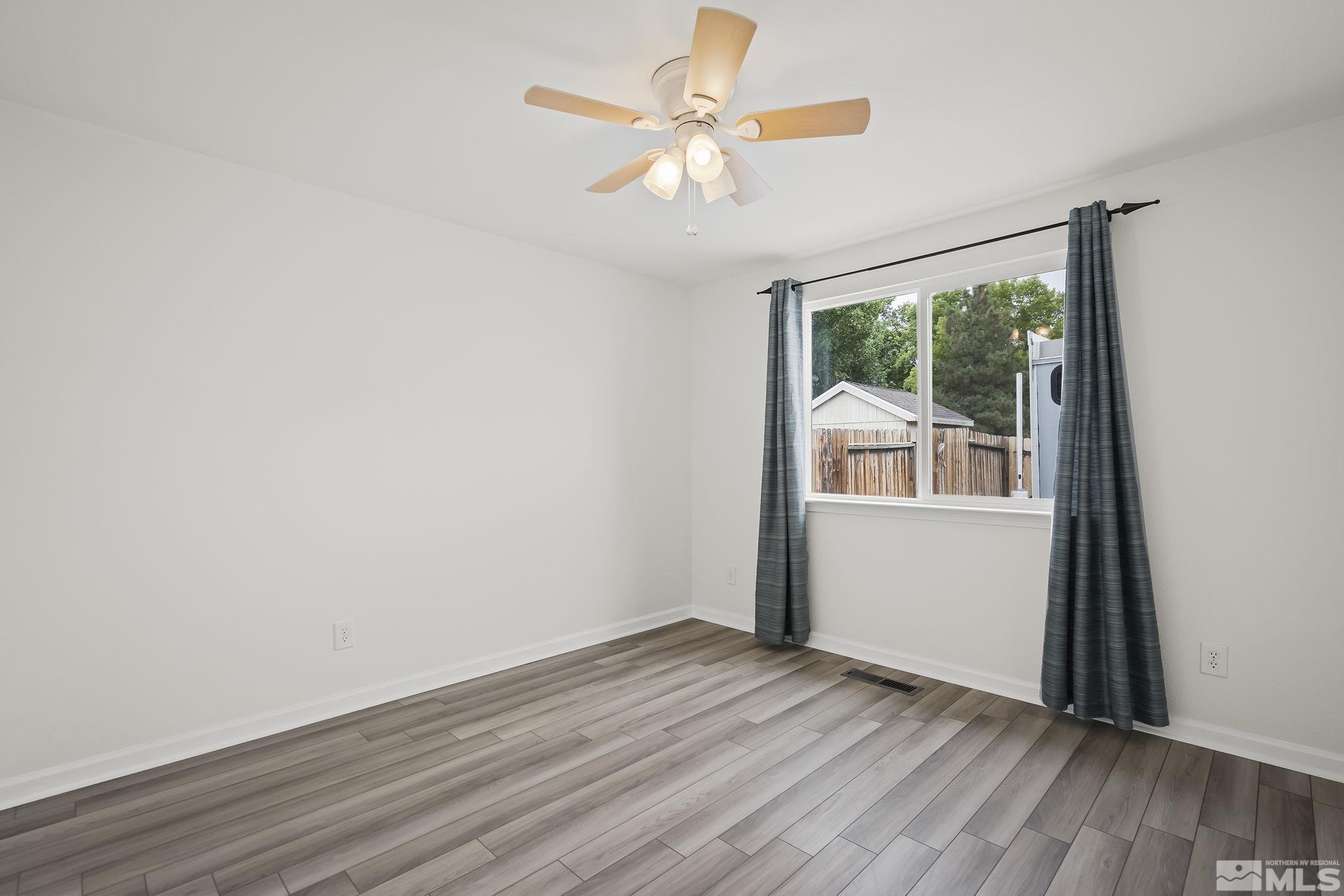 150 Rosecrest Drive Fernley, NV 89408 - Photo 20 of 28 a view of an empty room with a window and wooden floor