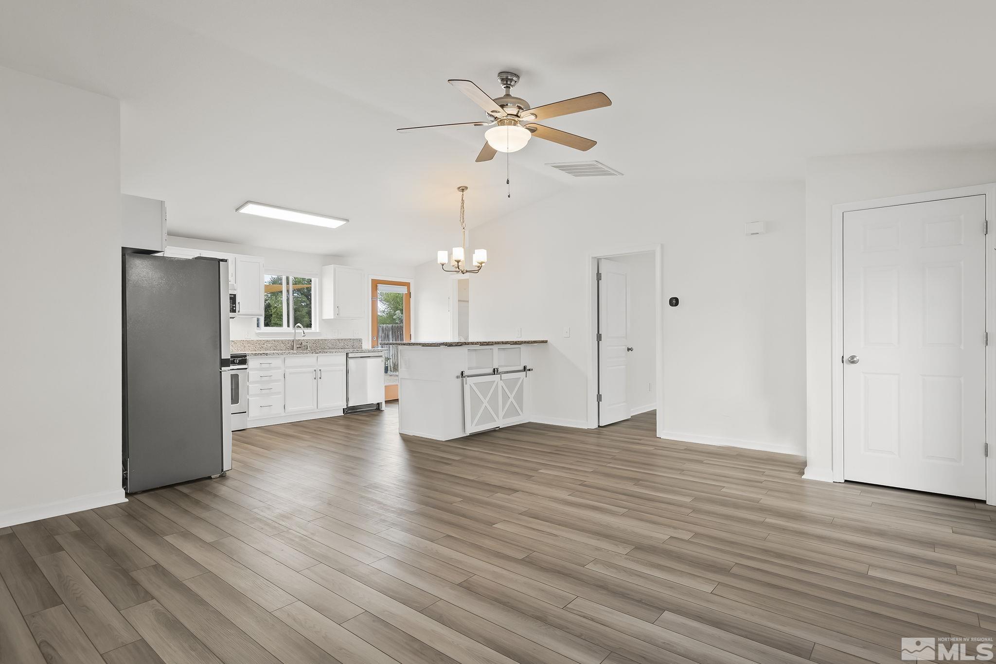 150 Rosecrest Drive Fernley, NV 89408 - Photo 4 of 28 a view of an empty room with wooden floor and a ceiling fan