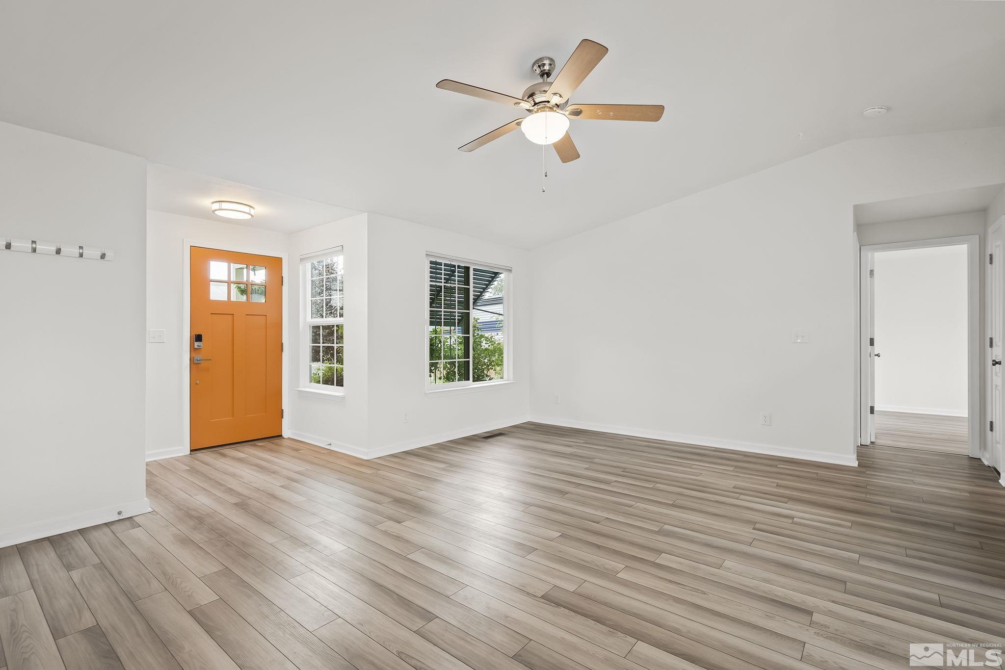 150 Rosecrest Drive Fernley, NV 89408 - Photo 6 of 28 an empty room with wooden floor chandelier fan and windows