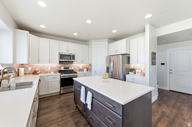 1434 West Stable Street Lindon, UT 84042 - Photo 17 of 76 Kitchen featuring stainless steel appliances, dark wood finished floors, a center island, two tone cabinets, and tasteful backsplash