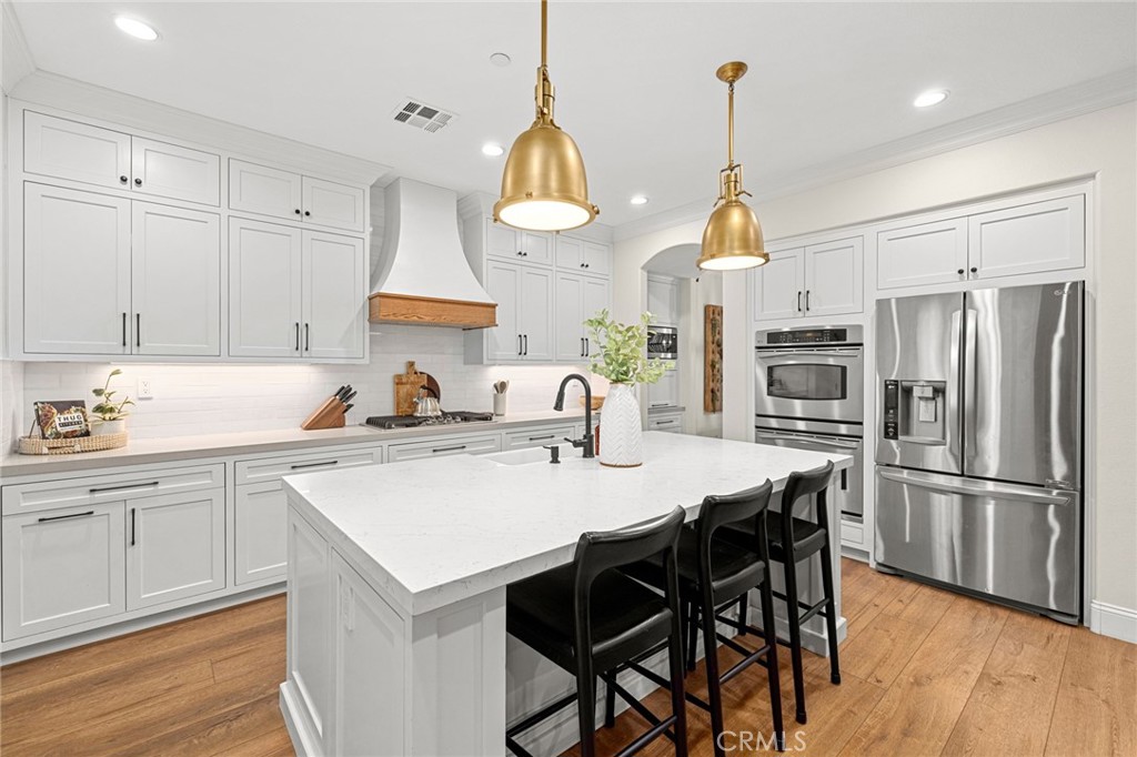 18 Bower Lane Ladera Ranch, CA 92694 - Photo 5 of 31 a kitchen with stainless steel appliances granite countertop a sink a stove a refrigerator and island with wooden floor