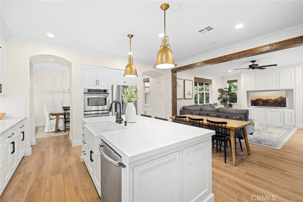 18 Bower Lane Ladera Ranch, CA 92694 - Photo 6 of 31 a kitchen with stainless steel appliances a stove a sink a wooden floor and white cabinets