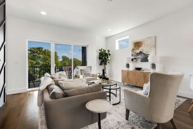 a living room with furniture kitchen view and a chandelier