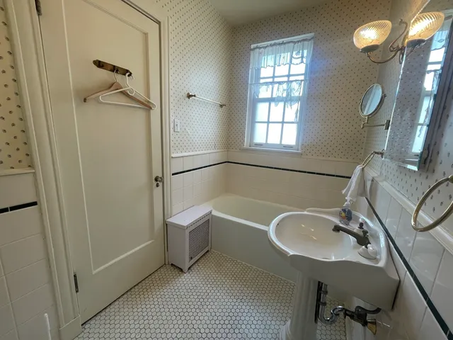a bathroom with a tub sink and mirror