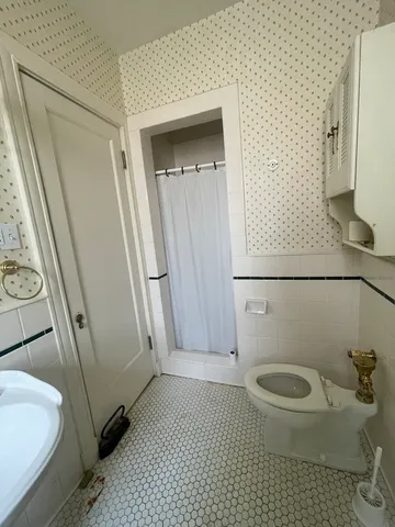 a bathroom with a granite countertop toilet and a sink