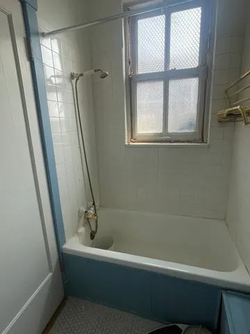 a bathroom with a bathtub and a window
