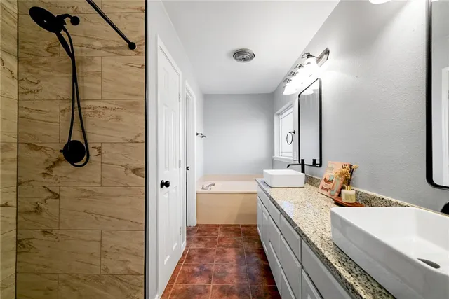 a bathroom with a double vanity sink a toilet and shower