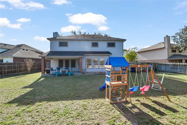a view of a house with backyard and sitting area
