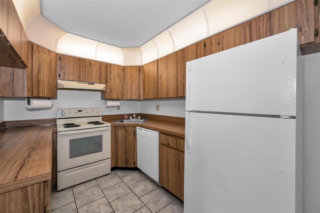 2687 Pine Ridge Way South, Unit B2 Palm Harbor, FL 34684 - Photo 11 of 68 a kitchen with a white cabinets and refrigerator
