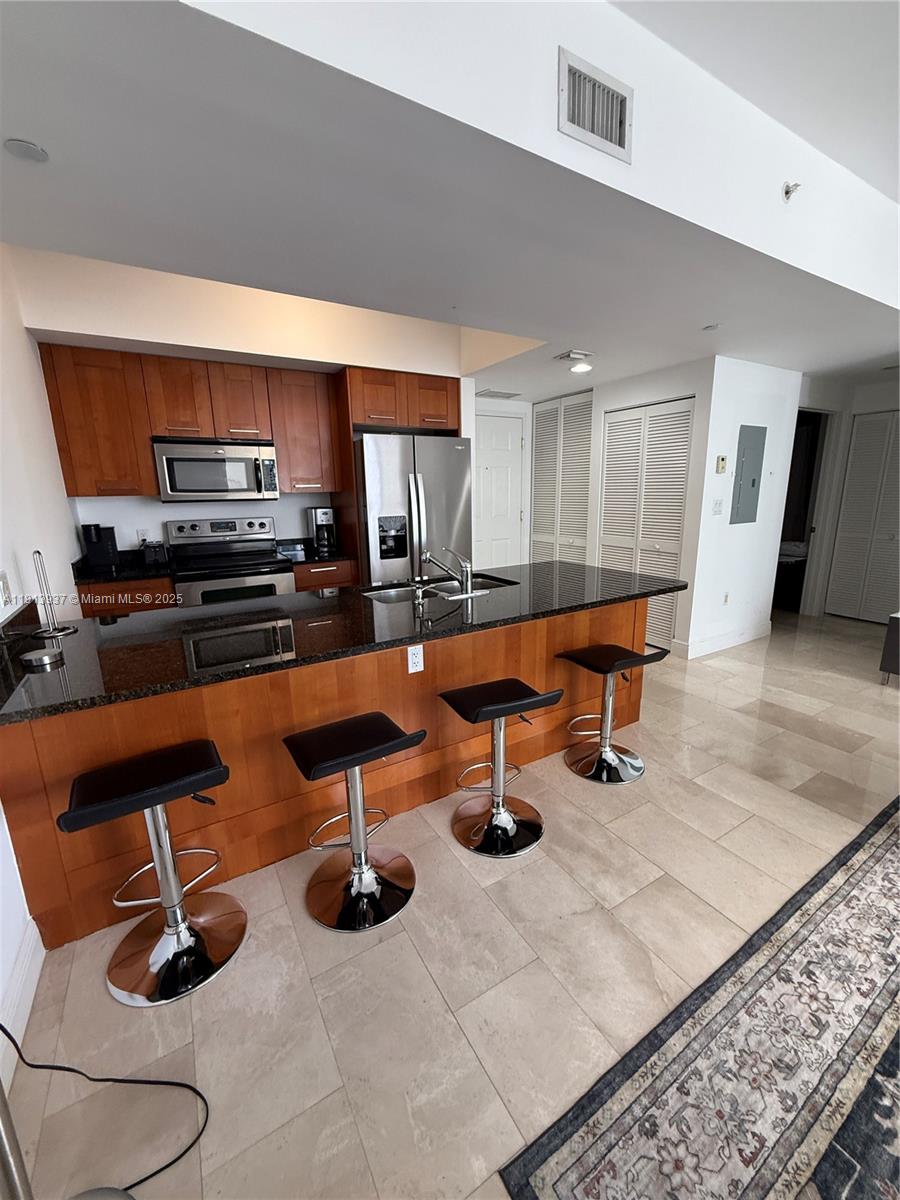 4100 Salzedo Street, Unit 811 Coral Gables, FL 33146 - Photo 16 of 28 a kitchen with stainless steel appliances kitchen island granite countertop a sink and a stove