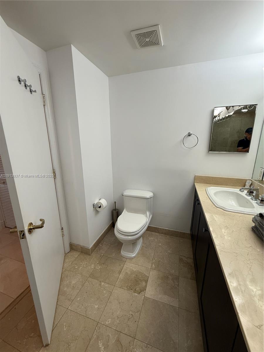 4100 Salzedo Street, Unit 811 Coral Gables, FL 33146 - Photo 20 of 28 a bathroom with a granite countertop sink toilet and a mirror