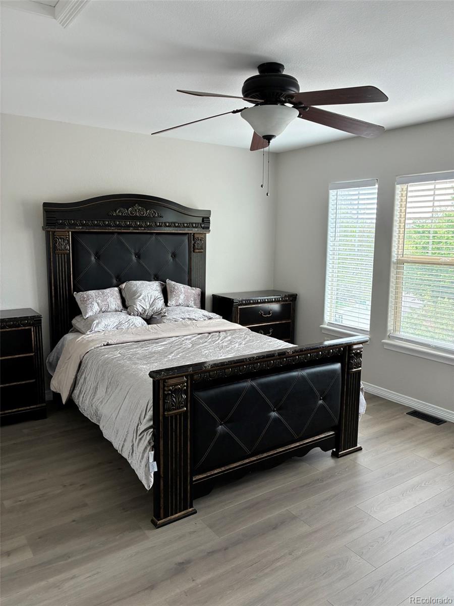 7242 South Rome Street Aurora, CO 80016 - Photo 17 of 33 a bedroom with bed and wooden floor