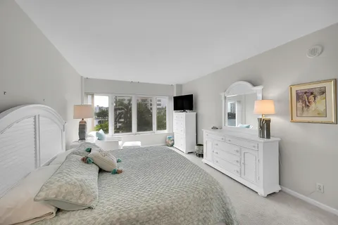 a large bedroom with a bed and large window