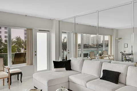 a living room with furniture large windows a rug and a glass door