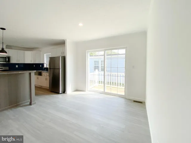 a view of a kitchen with refrigerator stove and wooden floor