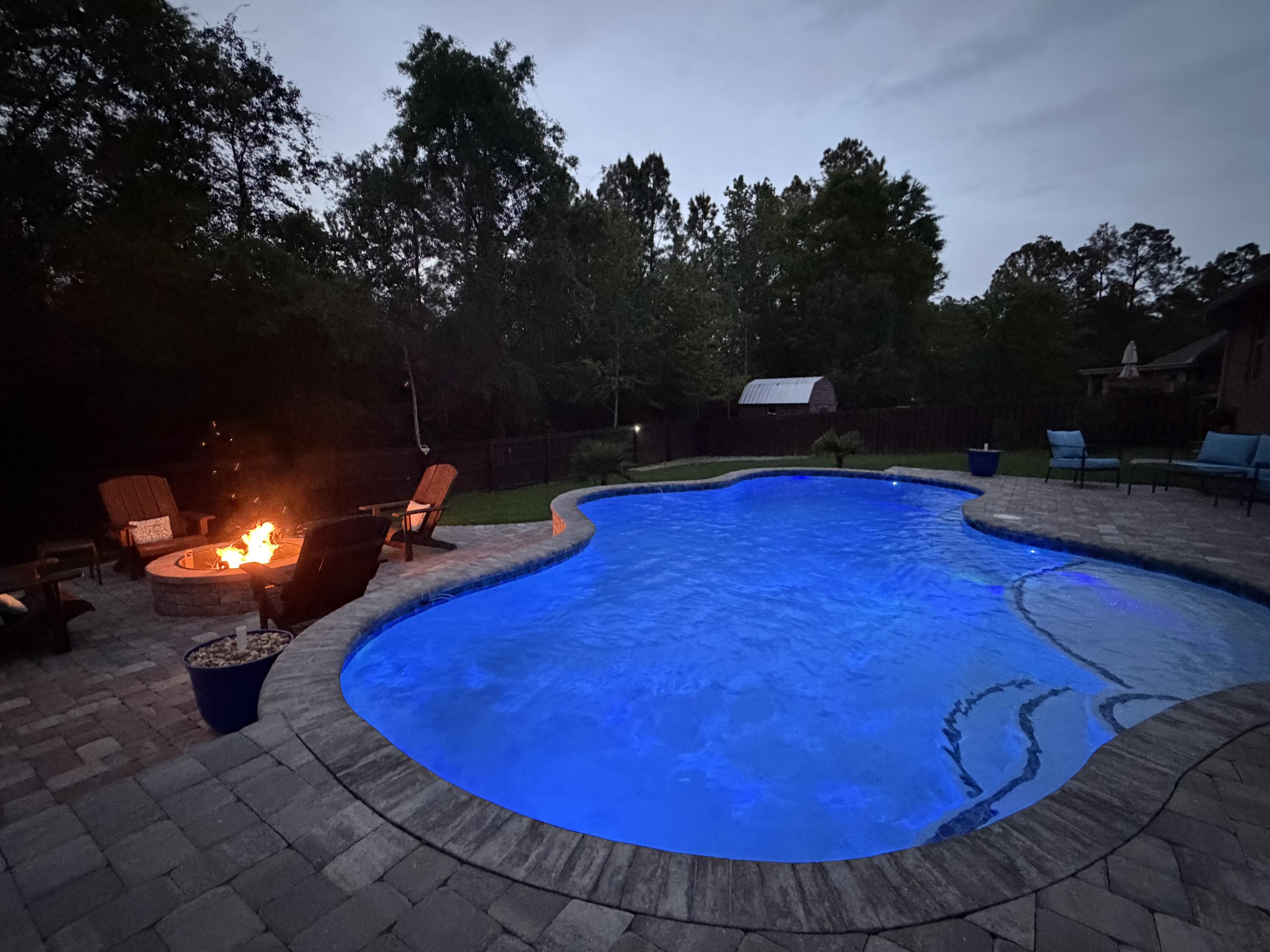 611 Terrier Trail Crestview, FL 32536 - Photo 12 of 64 a view of a swimming pool with an outdoor space and trees