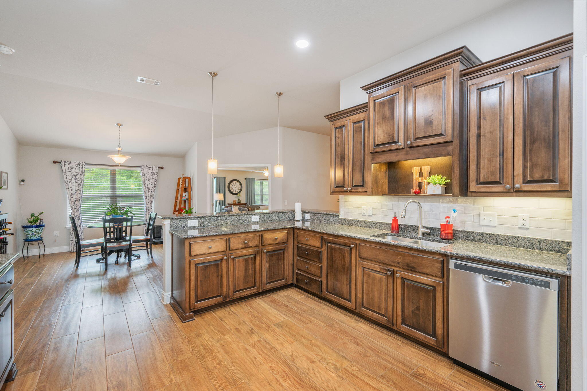611 Terrier Trail Crestview, FL 32536 - Photo 38 of 64 a kitchen with stainless steel appliances granite countertop wooden floors and wooden cabinets