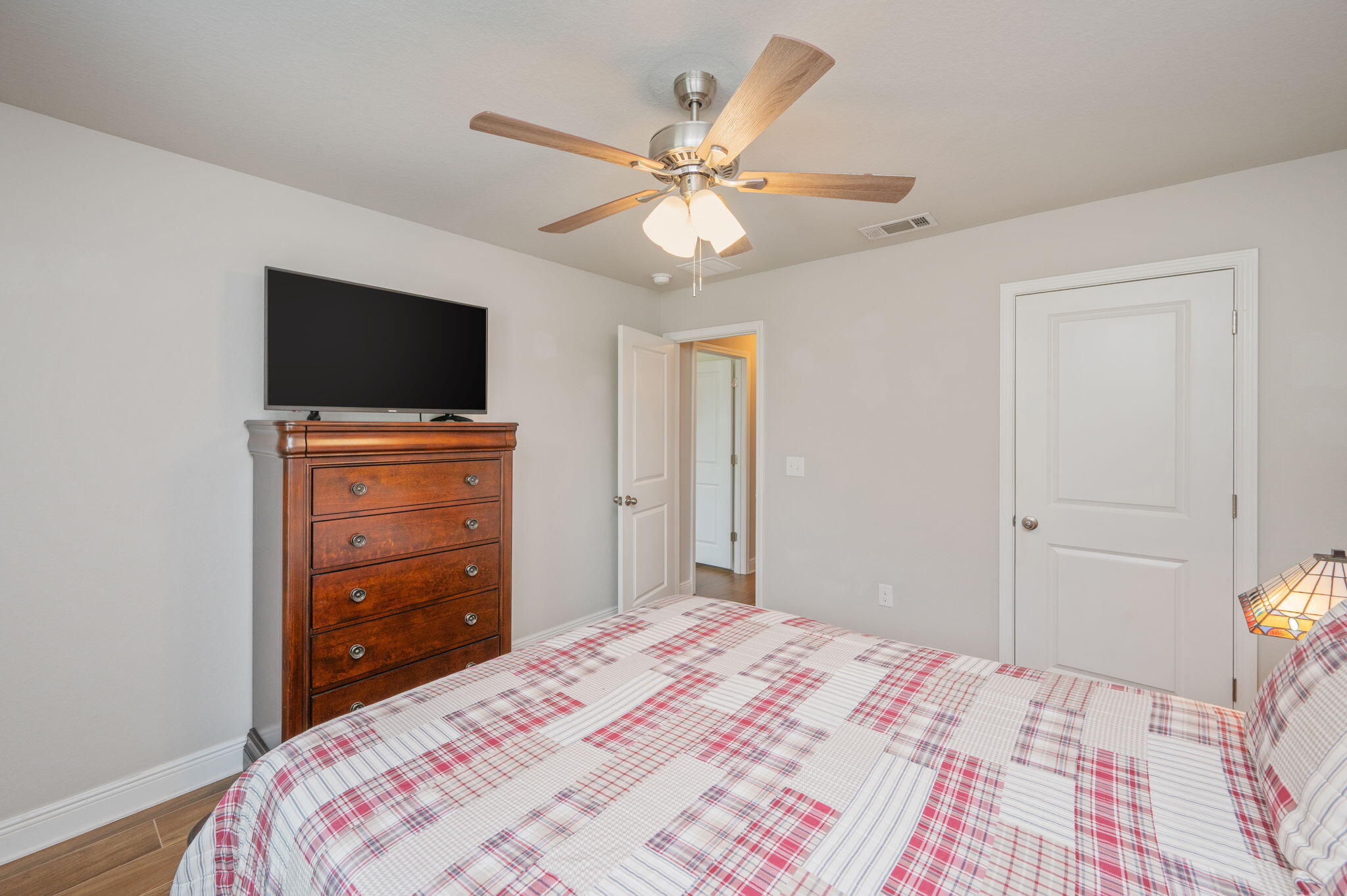 611 Terrier Trail Crestview, FL 32536 - Photo 53 of 64 a bedroom with a bed and a flat tv screen on dresser