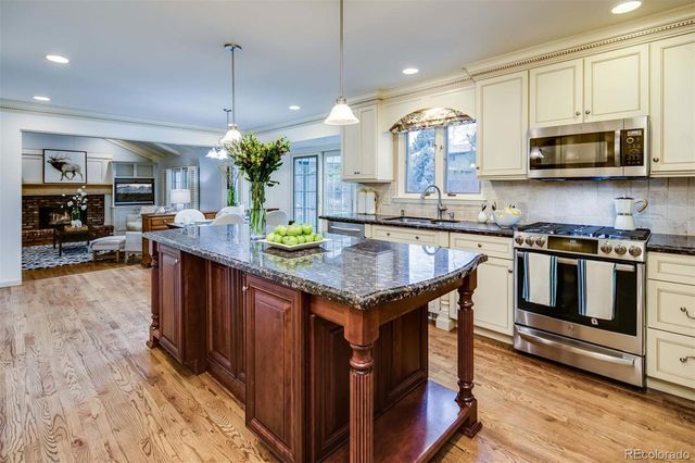 a kitchen with stainless steel appliances granite countertop a stove a sink and a microwave