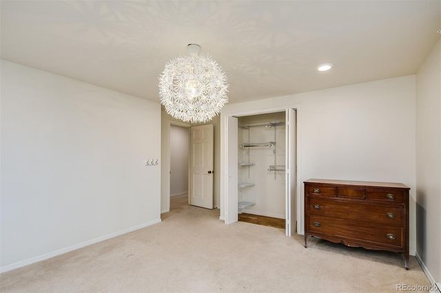 a view of an empty room and chandelier