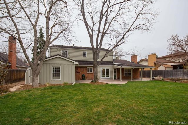 a front view of a house with a garden and trees