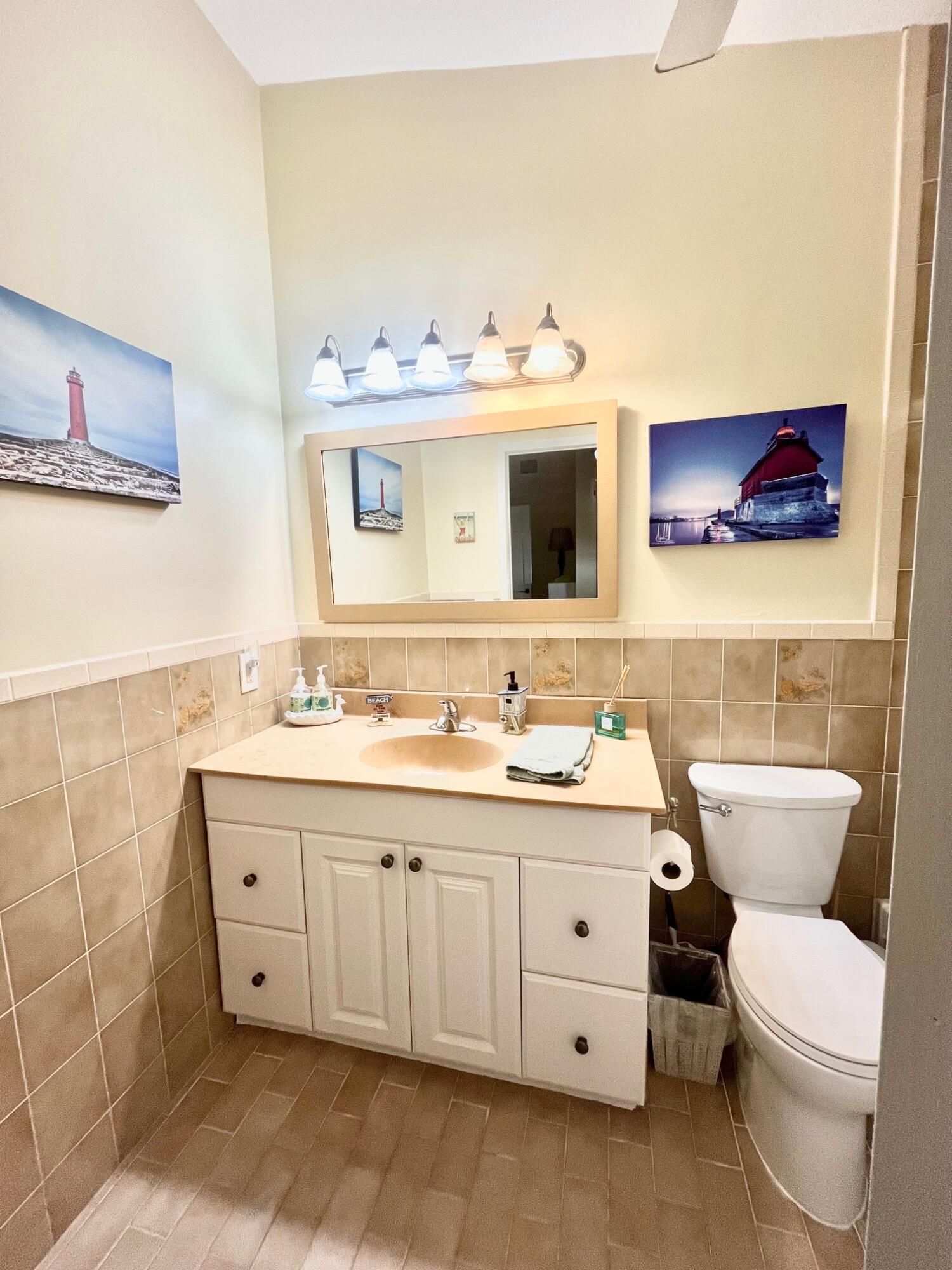 101620 Overseas Highway, Unit 5N Key Largo, FL 33037 - Photo 12 of 28 a bathroom with a toilet sink and mirror