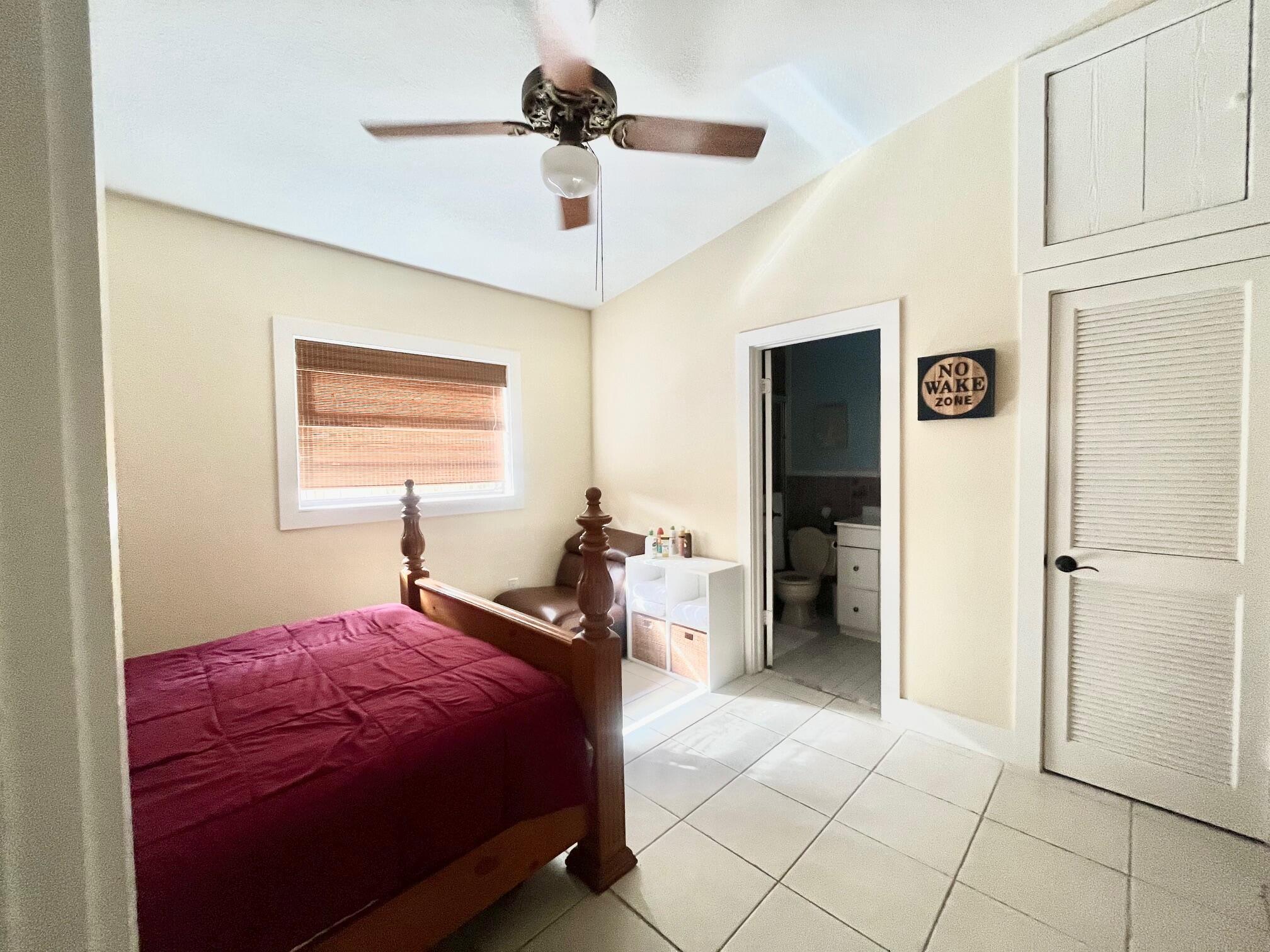 101620 Overseas Highway, Unit 5N Key Largo, FL 33037 - Photo 15 of 28 a bedroom with a bed and a chandelier