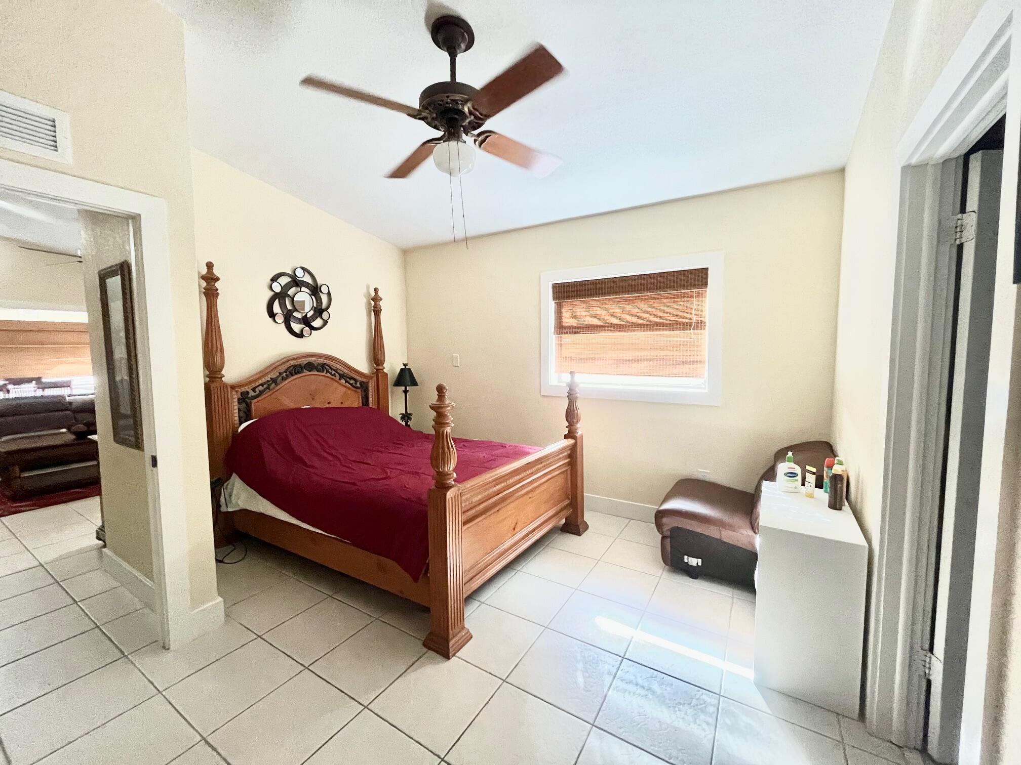 101620 Overseas Highway, Unit 5N Key Largo, FL 33037 - Photo 16 of 28 a bedroom with a bed and a chandelier