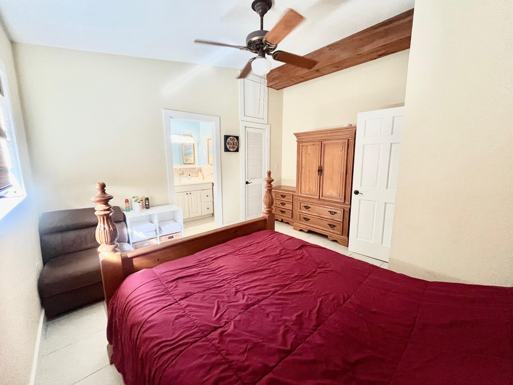 101620 Overseas Highway, Unit 5N Key Largo, FL 33037 - Photo 17 of 28 a bedroom with a bed and a couch