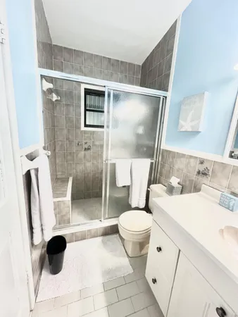 a bathroom with a granite countertop sink toilet and shower