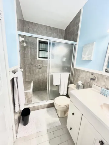 a bathroom with a granite countertop sink toilet and shower